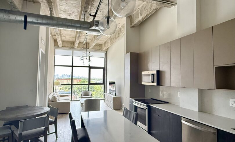 Modern kitchen with sleek cabinetry and a large window letting in natural light.